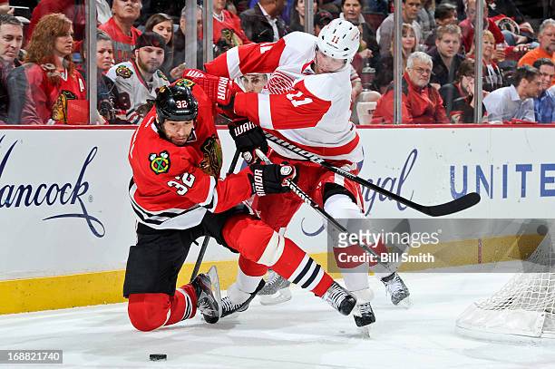 Michal Rozsival of the Chicago Blackhawks and Daniel Cleary of the Detroit Red Wings fight for the puck in Game One of the Western Conference...