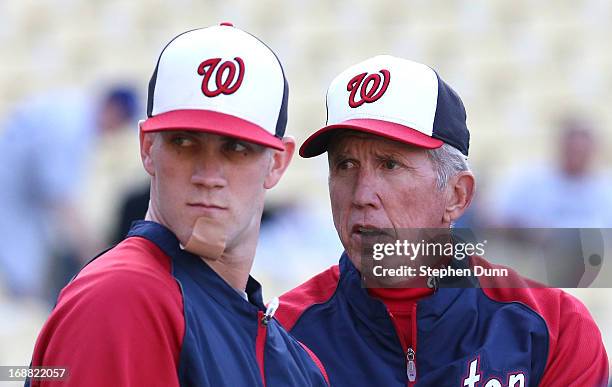 Manager Davey Johnson and Bryce Harper of the Washington Nationals talk as Harper takes batting practice wearing a bandage on his chin before the...