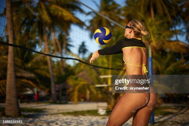 young sportswoman playing volleyball in summer day on the beach. - beach volleyball stock pictures, royalty-free photos & images