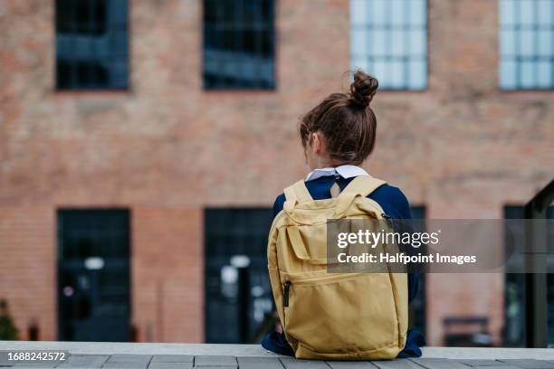 rear view of cute schoolgirl with a backpack going to school. - school uniform stock pictures, royalty-free photos & images