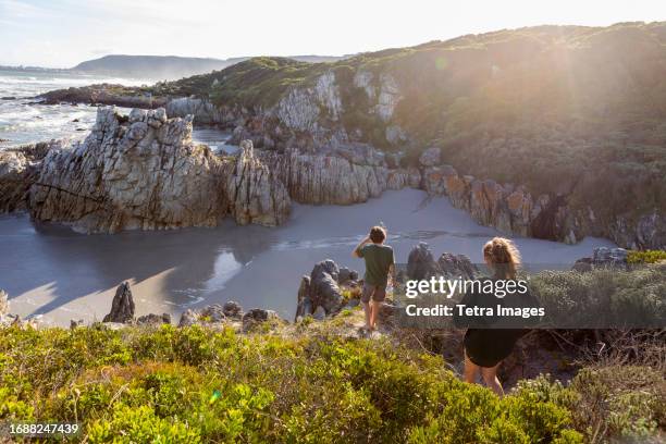 south africa, hermanus, brother (10-11) and sister (16-17) exploring rocky coastline in voelklip beach - hermanus stock-fotos und bilder