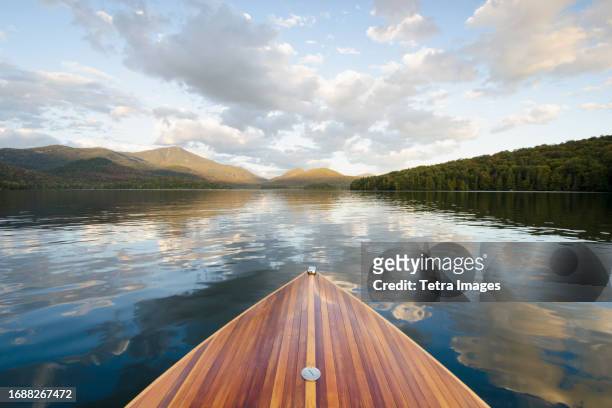 boat on lake placid with whiteface mountain in distance - lake placid foto e immagini stock