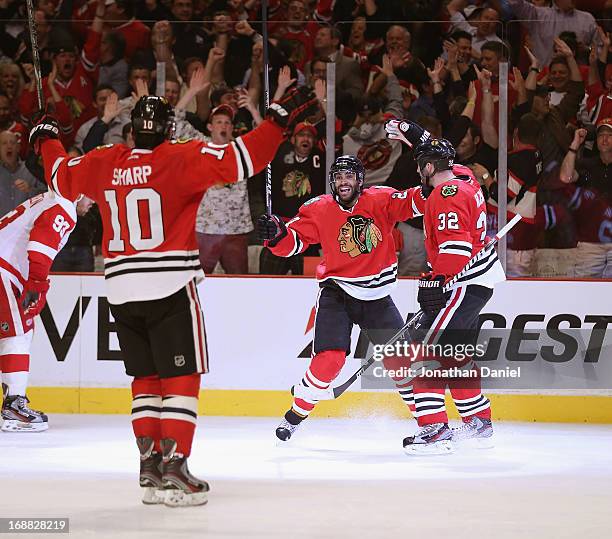 Patrick Sharp, Johnny Oduya and Michal Rozsival of the Chicago Blackhawks celebrate Oduyas' third period goal against the Detroit Red Wings in Game...