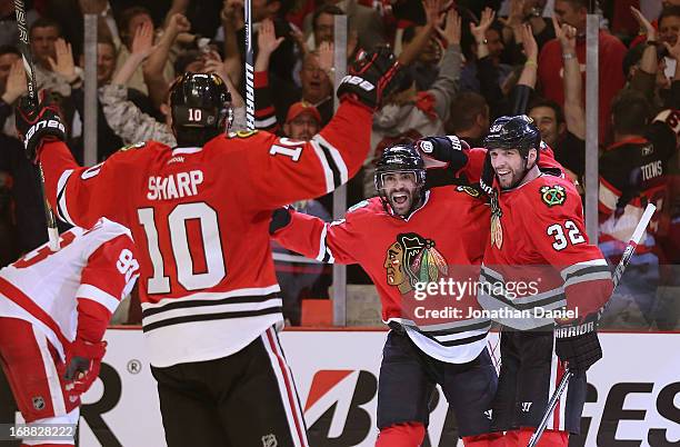 Patrick Sharp, Johnny Oduya and Michal Rozsival of the Chicago Blackhawks celebrate Oduyas' third period goal against the Detroit Red Wings in Game...