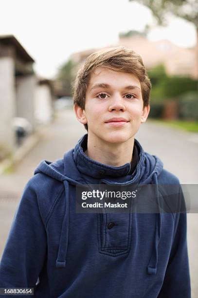 portrait of young boy standing on street - hoodie boy stock pictures, royalty-free photos & images