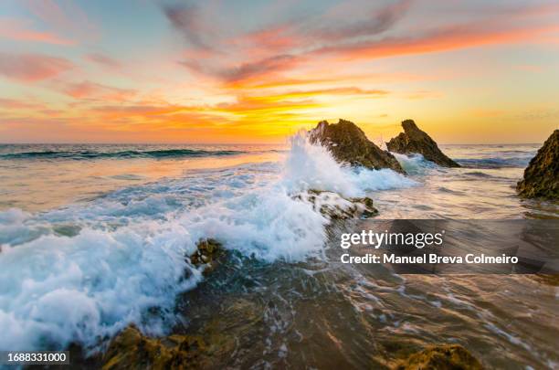 colorful sunset in cadiz - waves crashing on rocks stock pictures, royalty-free photos & images