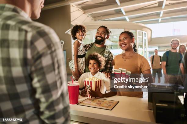 happy african american family at concession stand in cinema. - cinema ticket stock pictures, royalty-free photos & images