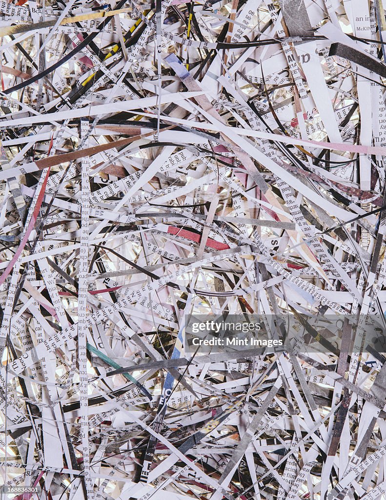 A pile of long thin shredded pieces of printed newspapers.