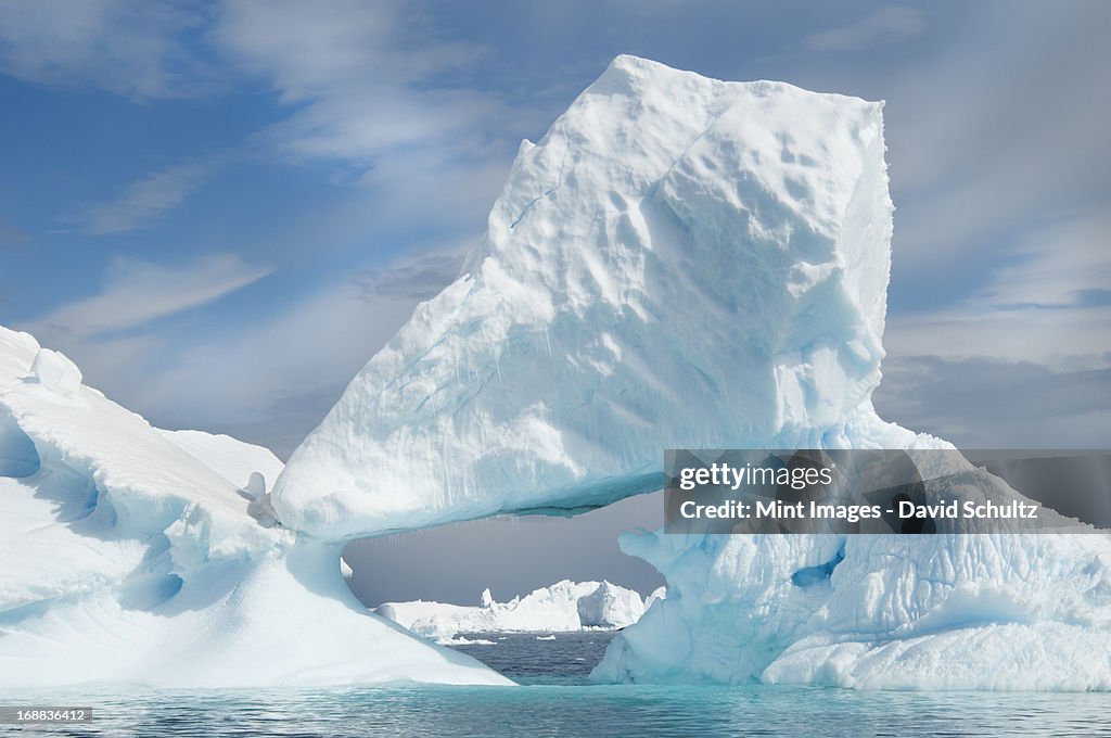 Icebergs floating on the Antarctic southern oceans. Eroded by wind and weather, creating natural ice arches.