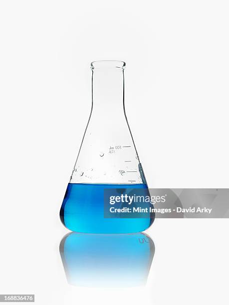 a conical scientific glassware flask partly filled with blue liquid. - conical flask stock pictures, royalty-free photos & images