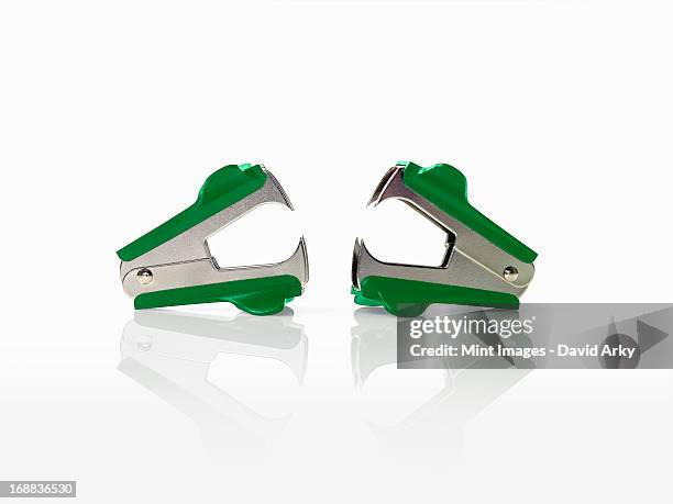two green staple removers with pincers. - metal stapler stock pictures, royalty-free photos & images