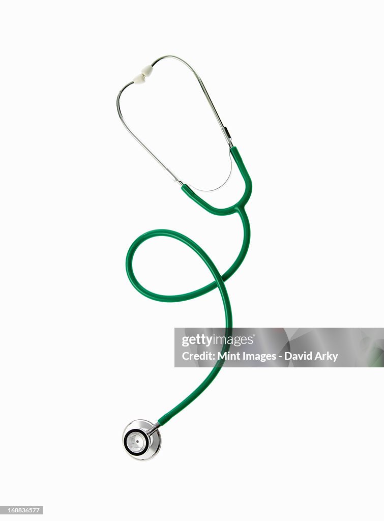 A doctor's stethoscope with green tubing, a conceptual illustration of alternative medicine and wellbeing. 
