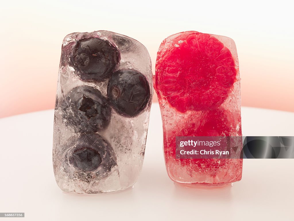 Blueberries and raspberries frozen in ice cubes