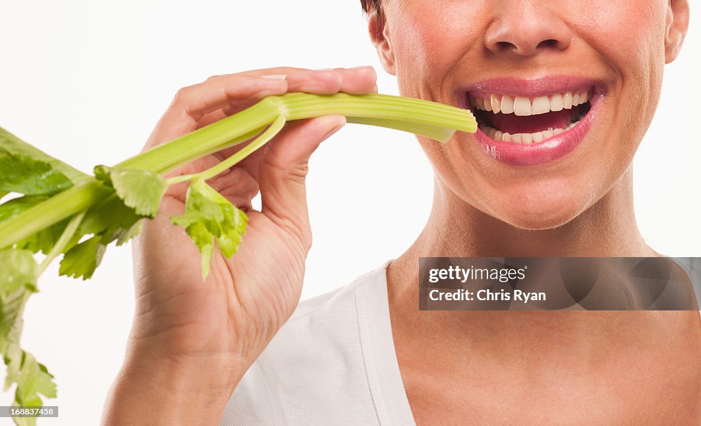 Woman biting end of celery stalk