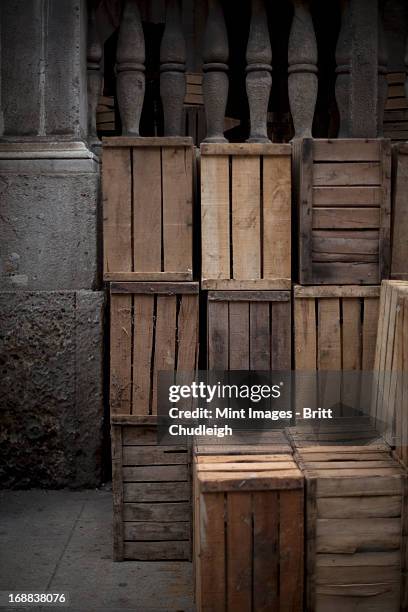 a stack of wooden crates, in the corner of a room.  - crate stock pictures, royalty-free photos & images