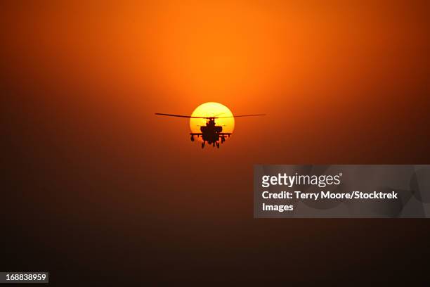 an ah-64d apache helicopter flying into the sun over tikrit, iraq, during operation iraqi freedom. - iraq tikrit stock pictures, royalty-free photos & images