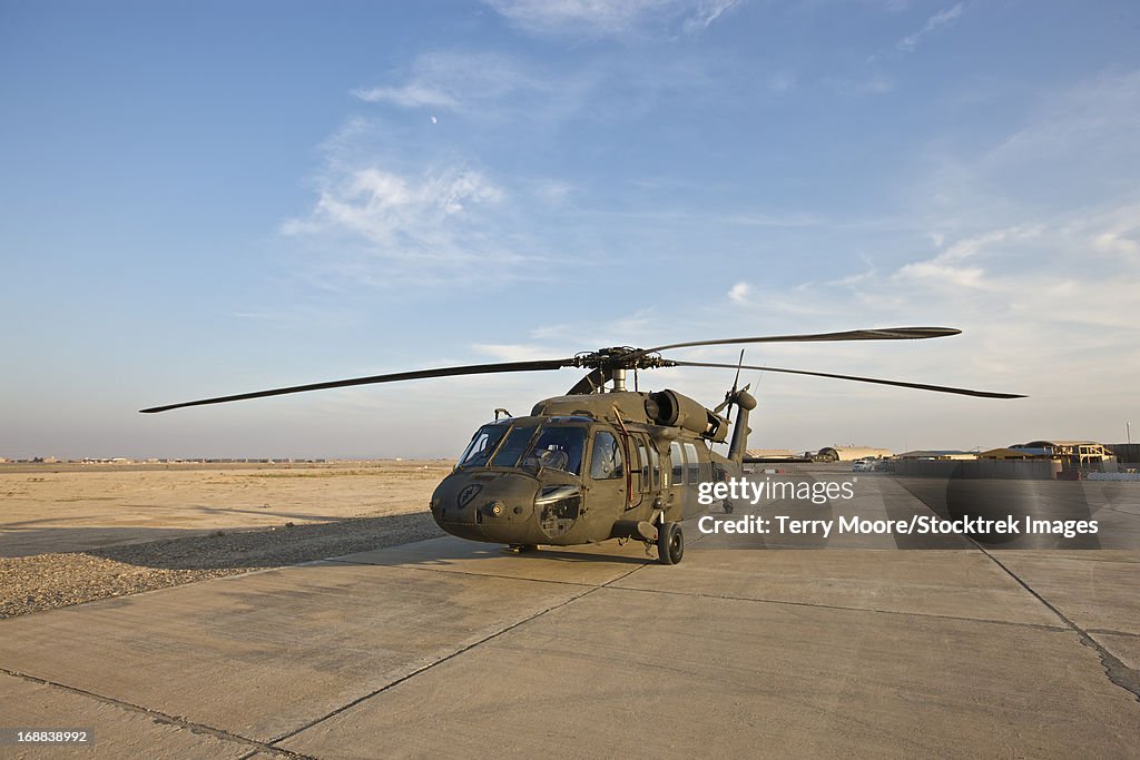 A UH-60 Black Hawk parked on the maintenance pad at a military base in Tikrit, Iraq.