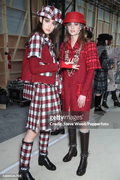 Backstage at the Chanel show during Paris Fashion Week Autumn/Winter 2016/17, one model wears a skirt suit in broad red, white and black checks with...