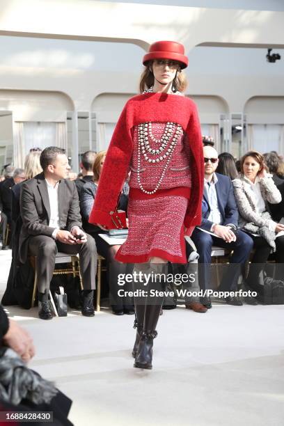 Model walks the runway at the Chanel show during Paris Fashion Week Autumn/Winter 2016/17, she wears a classic Chanel skirt suit in red tweed with a...