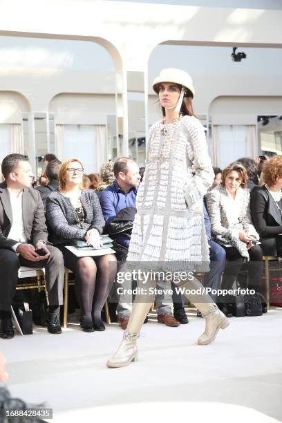 Model walks the runway at the Chanel show during Paris Fashion Week Autumn/Winter 2016/17, she wears a knee length swing coat in white ruched wool...