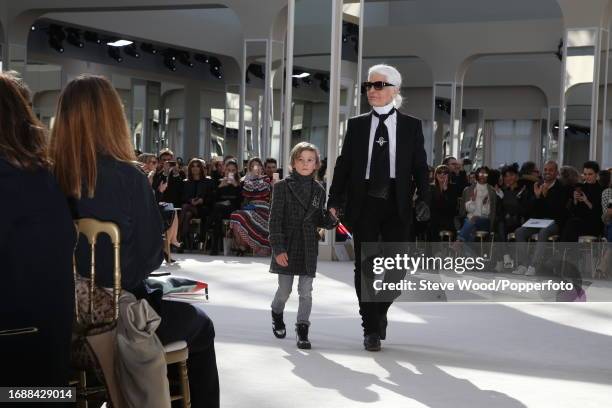 Designer Karl Lagerfeld walks the runway with godson Hudson Kroenig at the Chanel show during Paris Fashion Week Autumn/Winter 2016/17, Hudson wears...