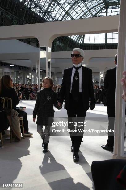 Designer Karl Lagerfeld walks the runway with godson Hudson Kroenig at the Chanel show during Paris Fashion Week Autumn/Winter 2016/17, Hudson wears...