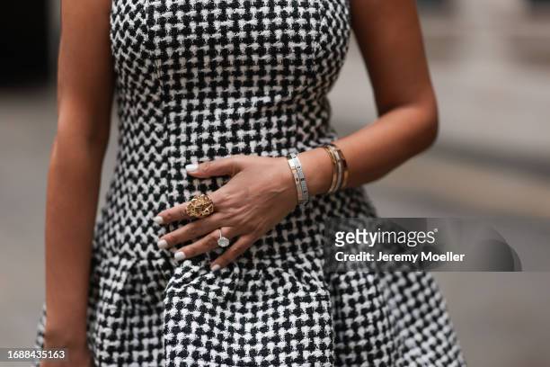 Tina Odjaghian is seen wearing silver a black/white checked mini dress from Carolina Herrera, two golden and two silber with rhinestones covered Love...