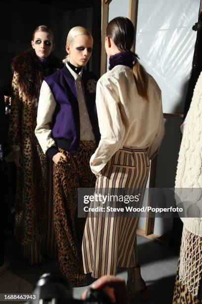 Backstage at the Dries Van Noten show during Paris Fashion Week Autumn/Winter 2016/17, two models wear leopard print and striped trousers with...