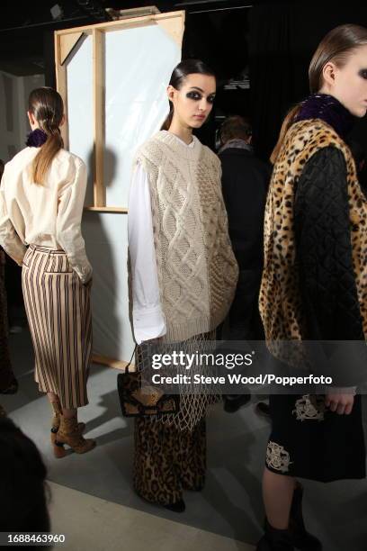 Backstage at the Dries Van Noten show during Paris Fashion Week Autumn/Winter 2016/17, a model wears a sleeveless cricket sweater over a white shirt,...