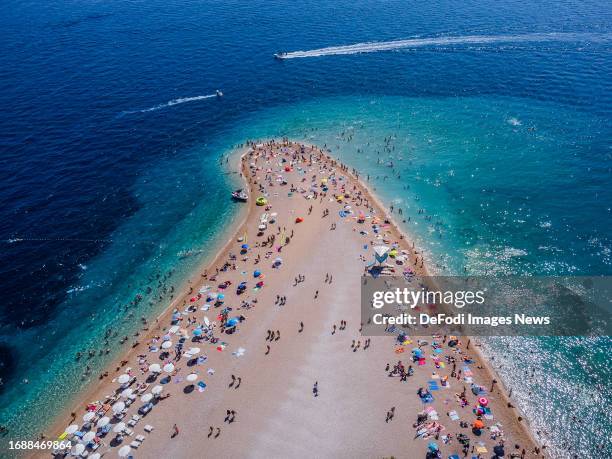 Tourists are seen on a beach known as Zlatni rat near Bol at the Croatian Adriatic island of Brac, 450 km southeast from the capital Zagreb on August...