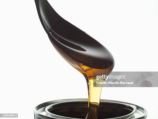 close up of honey dripping from spoon - molasses bildbanksfoton och bilder