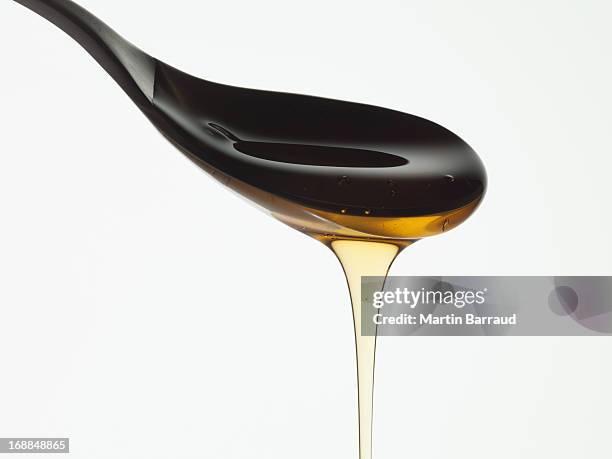 close up of honey dripping from spoon - molasses 個照片及圖片檔