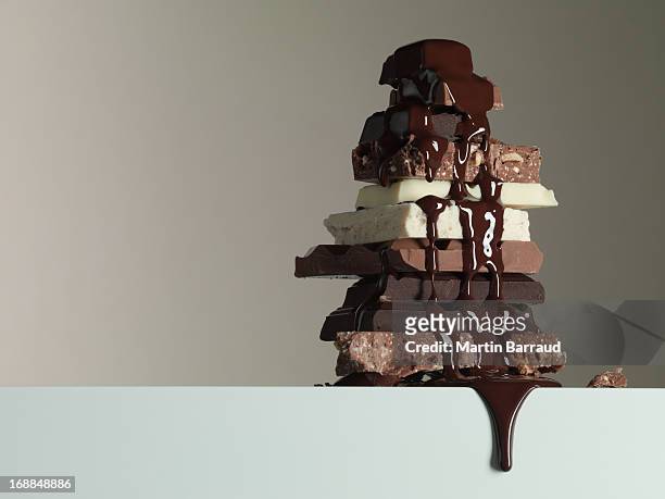 schokoladen-sirup tropfen auf stapel schokolade bars - temptation stock-fotos und bilder