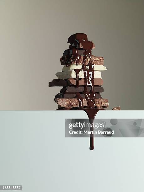 chocolate syrup dripping over stack of chocolate bars - chocolate drip stock pictures, royalty-free photos & images