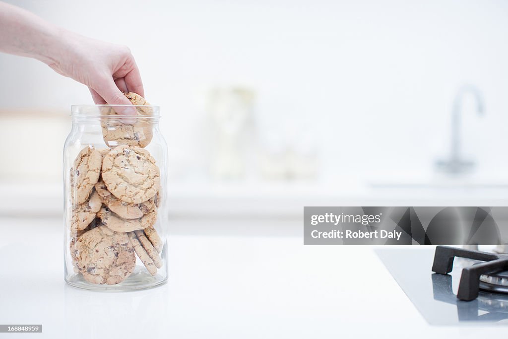 Mains pour atteindre pour cookie en pot