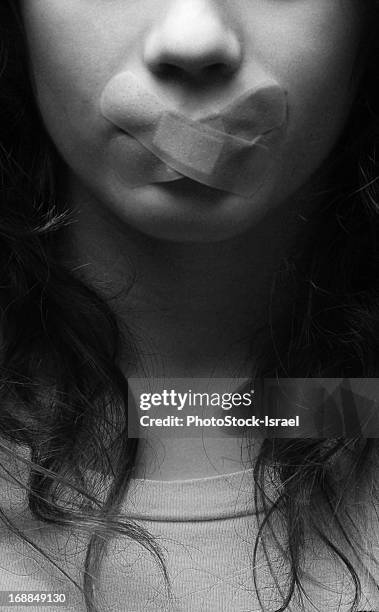 woman with bandage over mouth - woman with finger on lips stock pictures, royalty-free photos & images