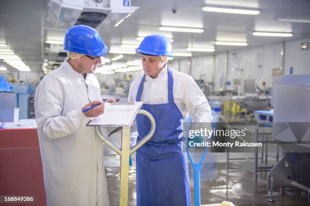 workers in food factory discussing notes - hair net stock pictures, royalty-free photos & images