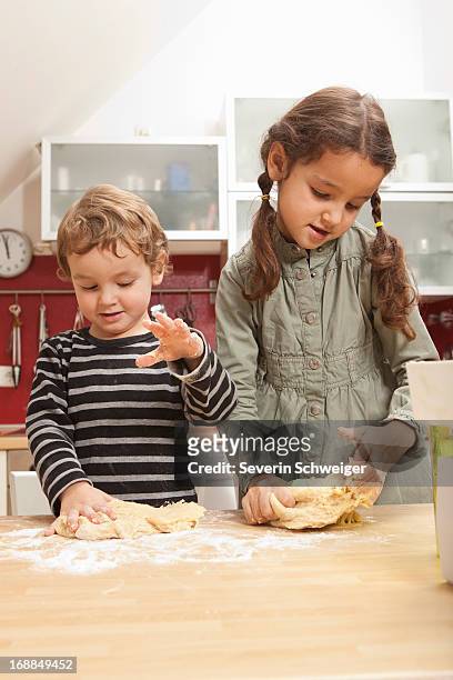 children kneading dough in kitchen - bruder schwester kochen stock-fotos und bilder