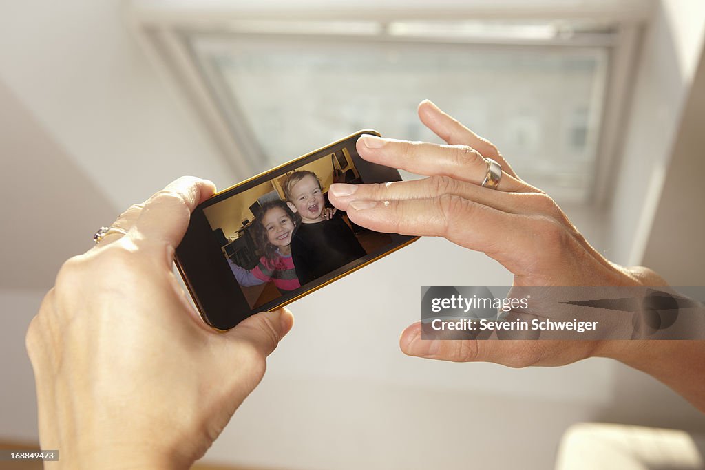 Woman examining picture on cell phone