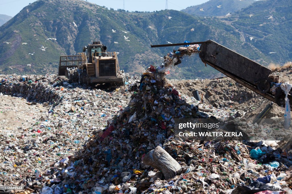Machinery dumping waste in landfill
