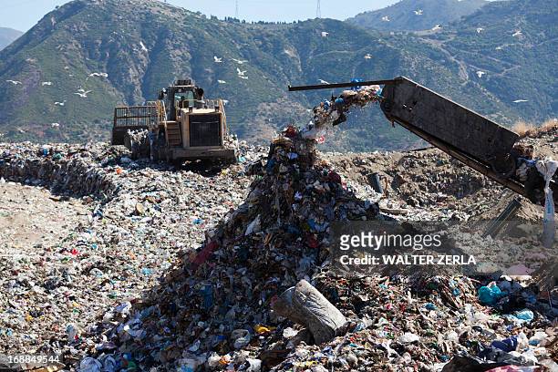 machinery dumping waste in landfill - landfill stock pictures, royalty-free photos & images