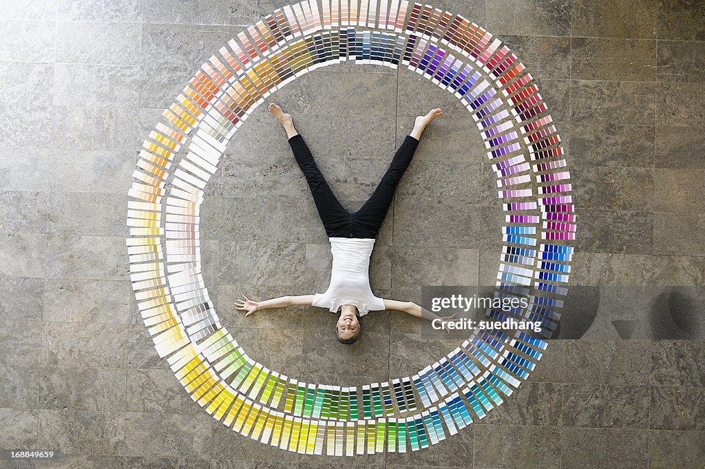 Businessman laying in paint swatches