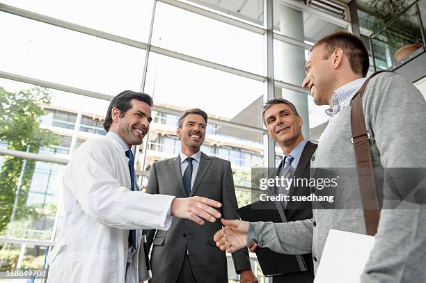 doctor and businessman shaking hands - doctor partnership stock pictures, royalty-free photos & images