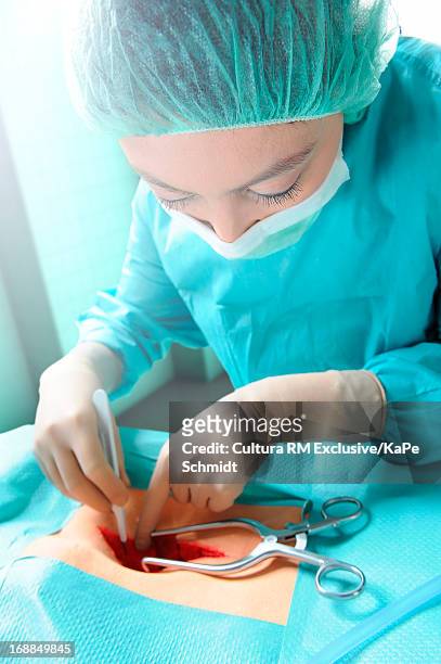 surgeon performing operation - retractor stock pictures, royalty-free photos & images