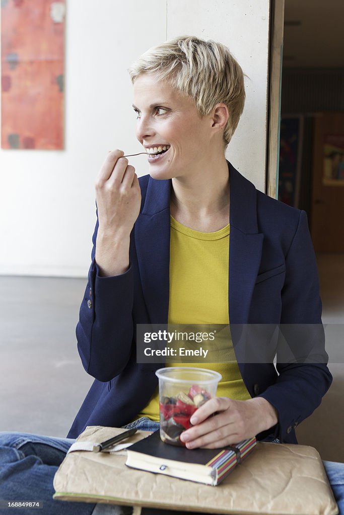 Smiling woman eating salad