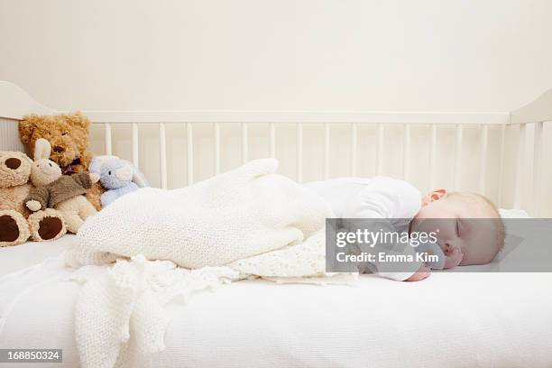 baby girl sleeping in crib - wieg stockfoto's en -beelden