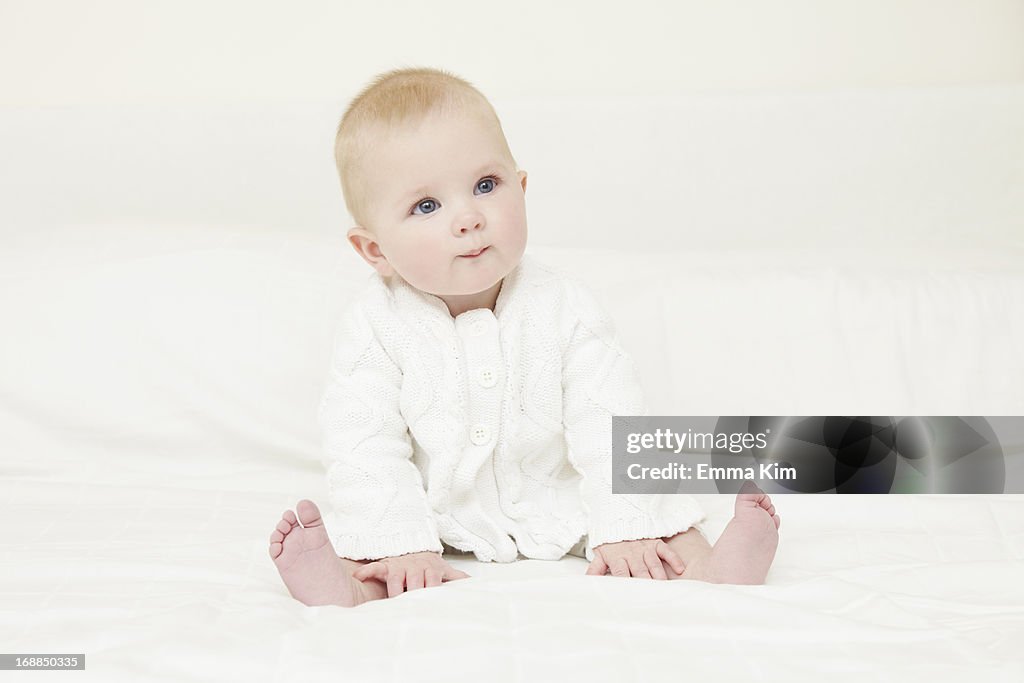 Baby girl sitting on sofa