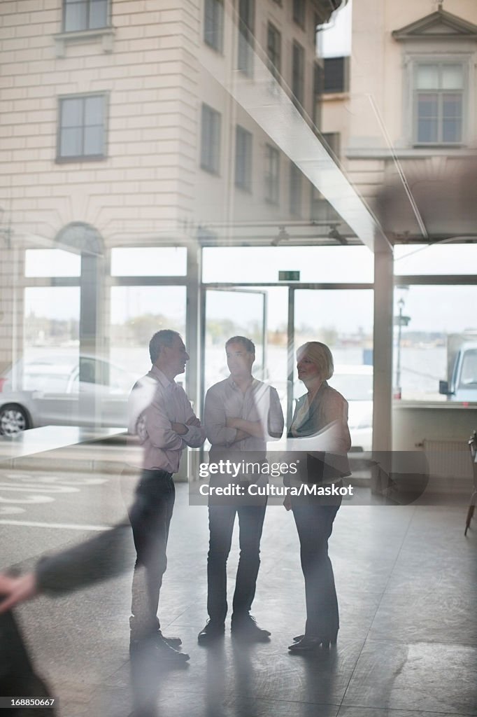 Business people reflected in window