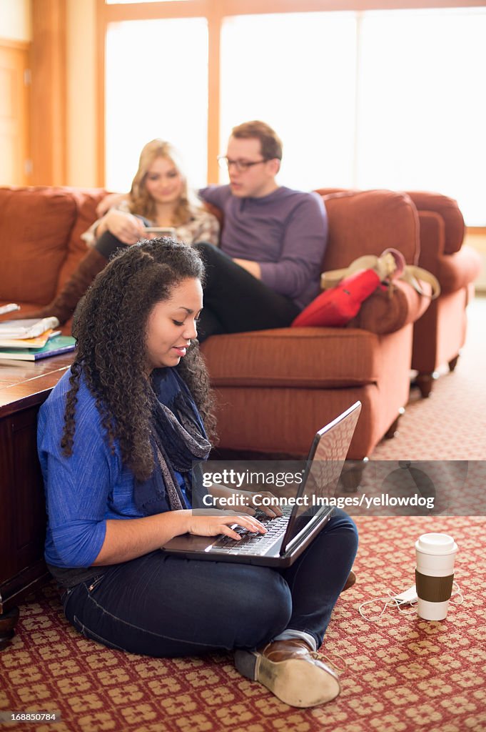 Woman using laptop on floor