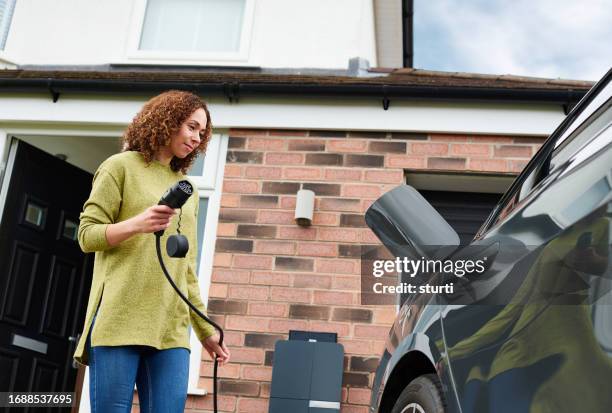 charging the electric car at home - electric car home stock pictures, royalty-free photos & images